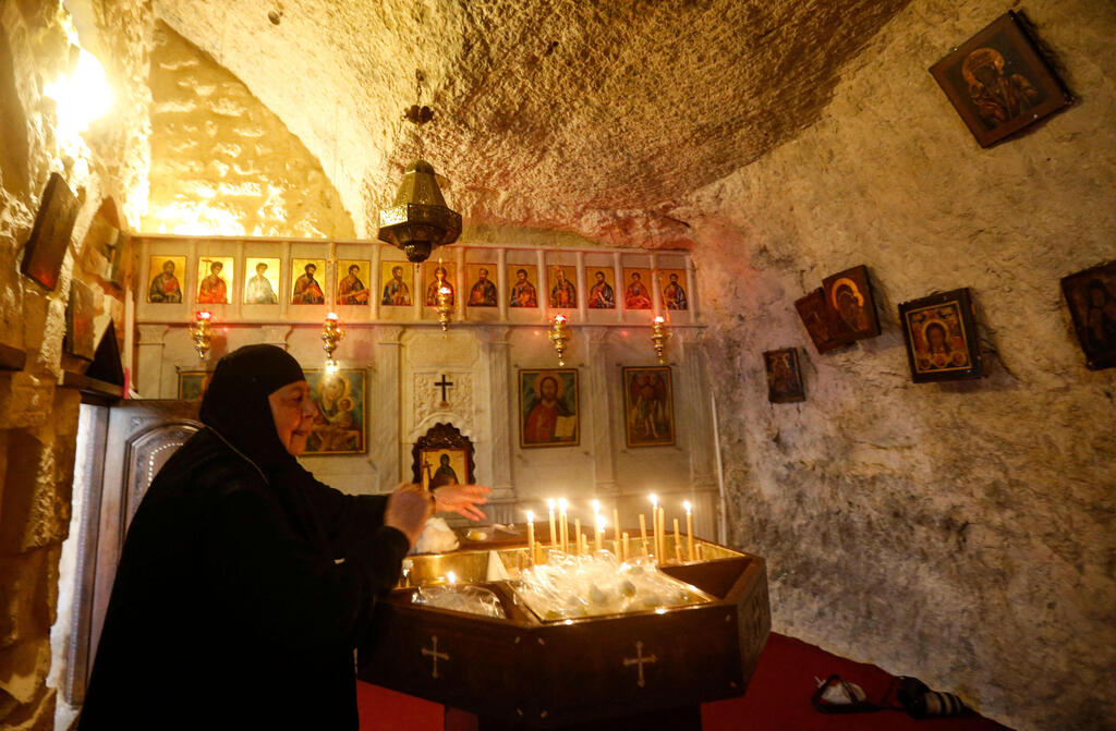 A nun lights candles inside the monastery of Mar Taqla in the village of Maalula 