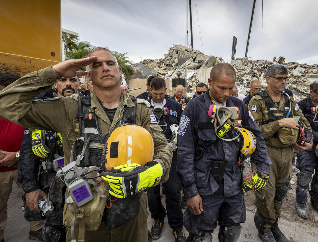A member of the Israeli search and rescue team, left, salutes in front of the rubble that once was Champlain Towers South during a prayer ceremony, Wednesday, July 7, 2021, in Surfside, Fla (Photo: AP) A member of the Israeli search and rescue team, left, salutes in front of the rubble that once was Champlain Towers South during a prayer ceremony, Wednesday, July 7, 2021, in Surfside, Fla
