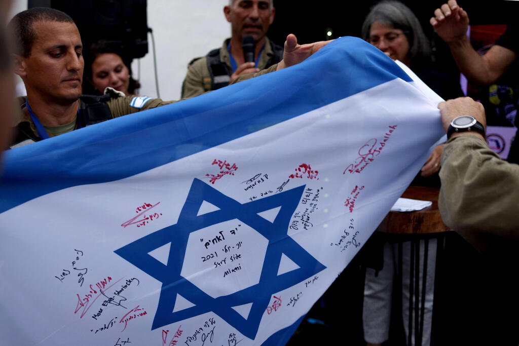 The Israeli rescue team presents Miami-Dade Mayor Daniella Levine Cava with an Israeli flag signed by all the team's members before their departure 