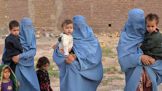 נשים ב בורקה בורחות מהעיר קלעה נאו, בירת מחוז בדגיס שבצפון-מערב אפגניסטן עקב קרבות עם הטליבאן טליבאן