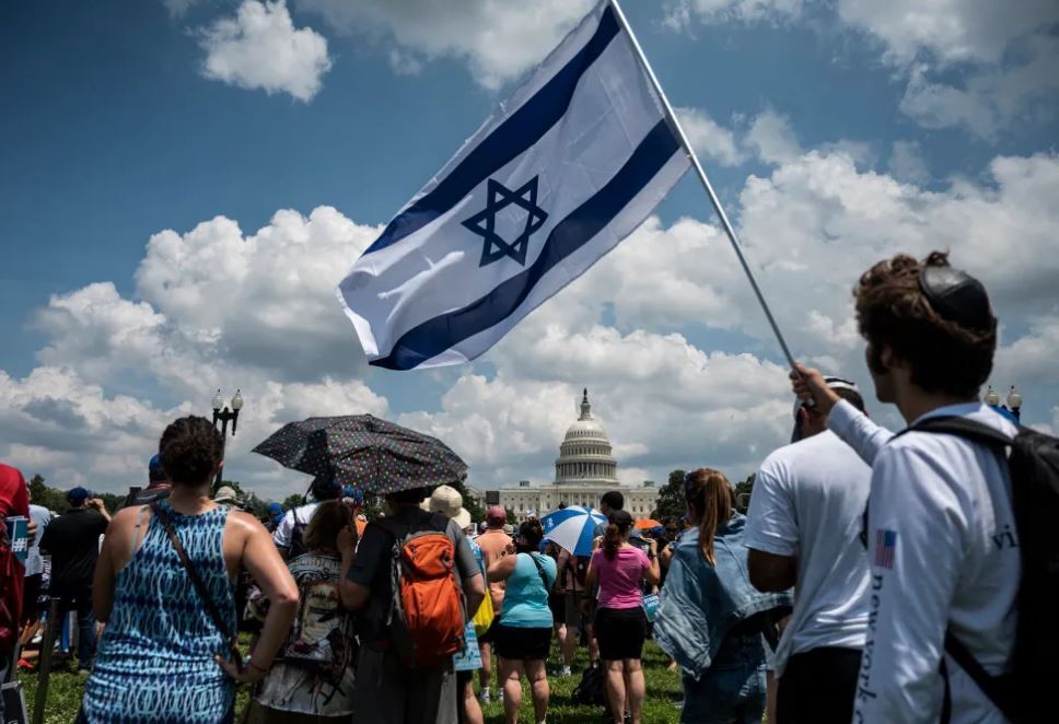 A man holds an Israeli national flag during a rally on 'No Fear: a Rally in Solidarity With the Jewish People' on the National Mall in Washington, DC on July 11, 2021.