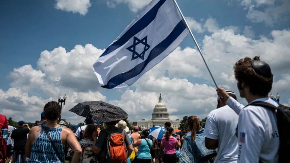 A man holds an Israeli national flag during a rally on 'No Fear: a Rally in Solidarity With the Jewish People' on the National Mall in Washington, DC on July 11, 2021.