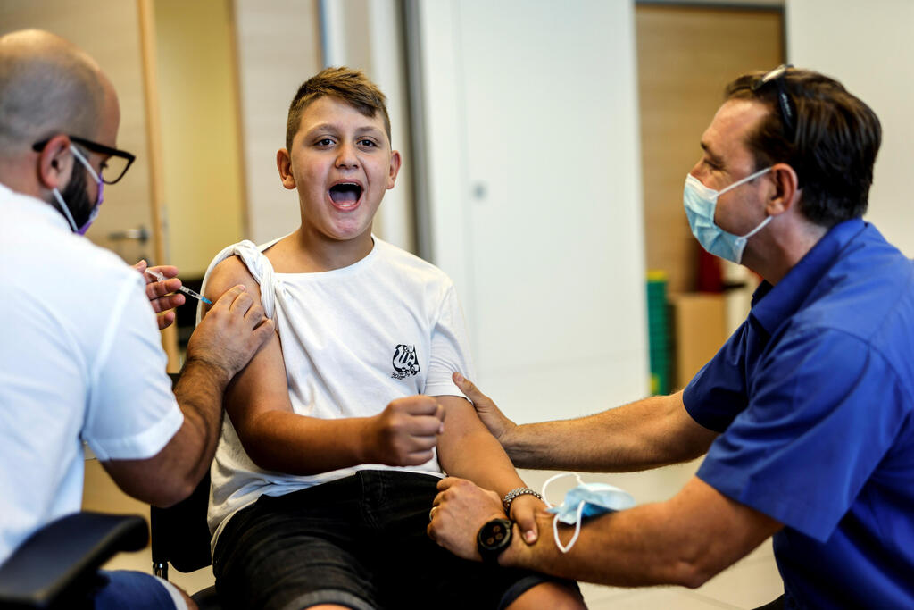 A youth receives a vaccination against the coronavirus disease (COVID-19) after Israel approved the usage of the vaccine for youngsters aged 12-15, at a Clalit healthcare maintenance organisation in Ashkelon 