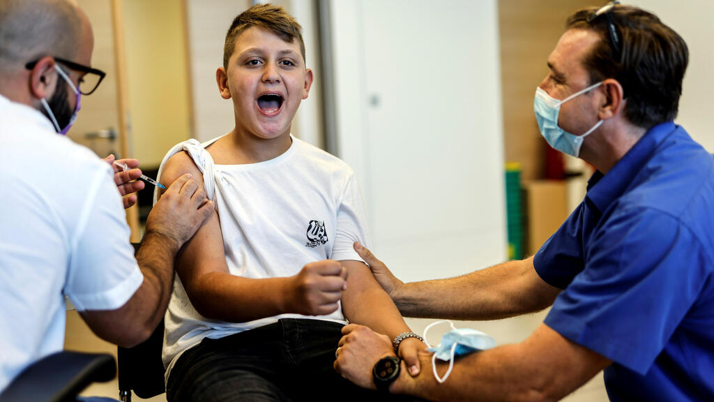 A youth receives a vaccination against COVID after Israel approved the usage of the vaccine for youngsters aged 12-15, at a Clalit HMO in Ashkelon (Photo: Reuters) A youth receives a vaccination against the coronavirus disease (COVID-19) after Israel approved the usage of the vaccine for youngsters aged 12-15, at a Clalit healthcare maintenance organisation in Ashkelon