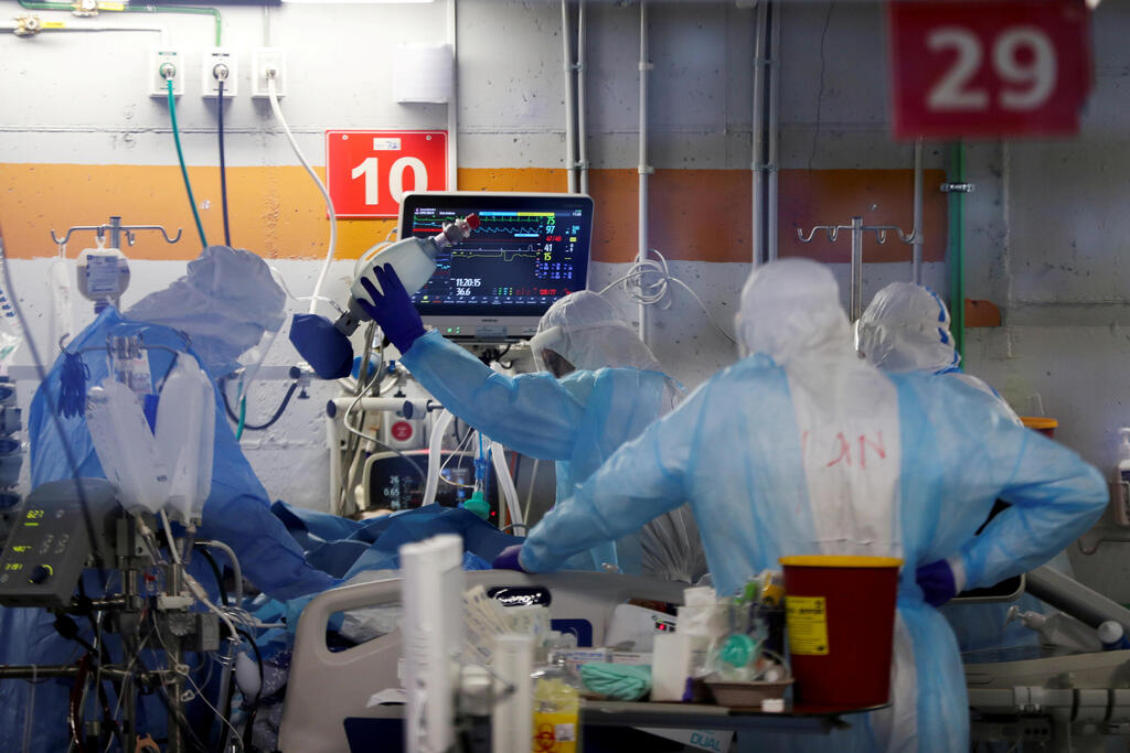 A coronavirus ward in a converted underground car park at Rambam Health Care Campus in Haifa (Photo: Reuters) Medical workers, seen through a window of an observation room, wear personal protective equipment (PPE) as they work inside an underground ward