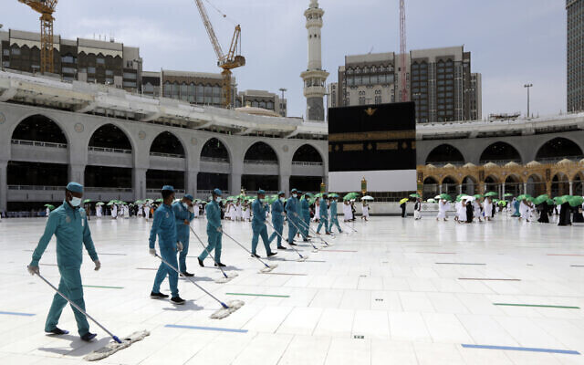Workers disinfect the grounds as Muslim pilgrims circumambulate around the Kaaba 