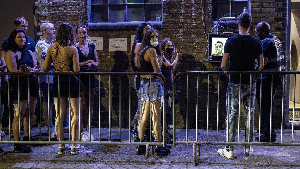 People line up in England to enter clubs after the curbs are lifted 