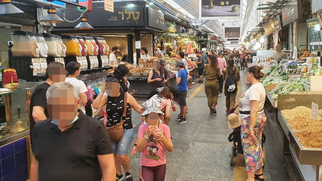עומס של אנשים בשוק מחנה יהודה שבוחרים לא לעטות מסכות