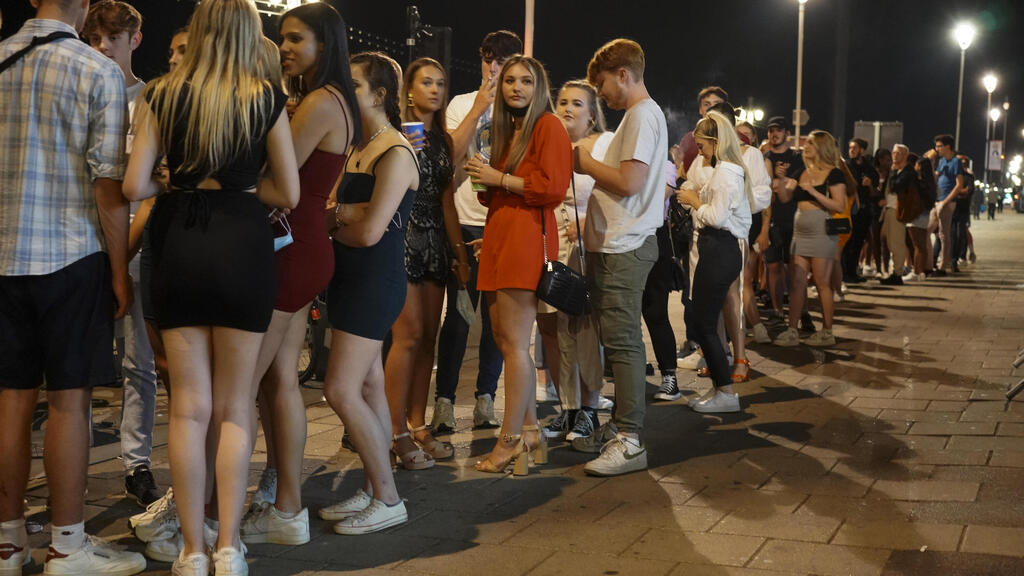 People line up in England to enter clubs after the curbs are lifted 