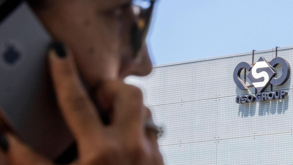 Israeli woman uses her iPhone in front of the building housing the Israeli NSO group, in Herzliya, near Tel Aviv 