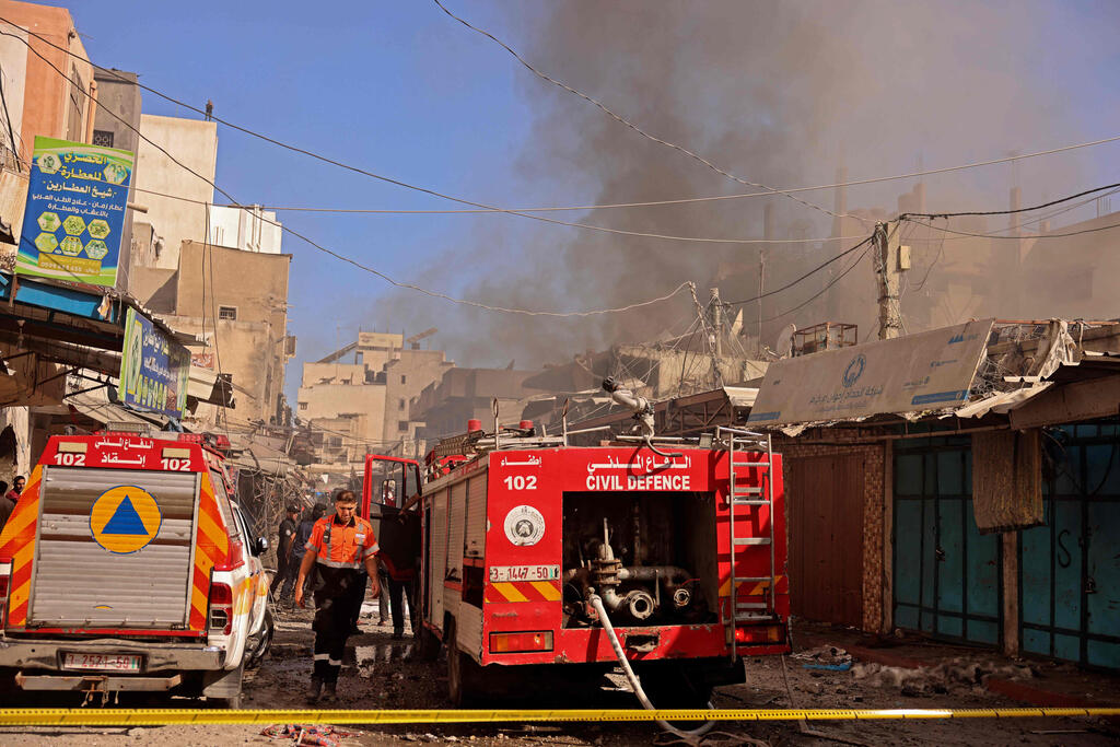 Palestinian rescuers and firefighters gather at the scene of a blast in Gaza City 