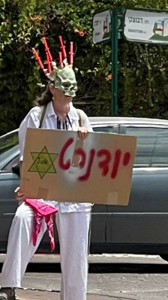  Одна из участниц протеста держит плакат со словом "юденрат"