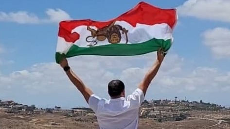 אחמד בטאבי עם הדגל הישן של איראן על הגבול עם לבנון
