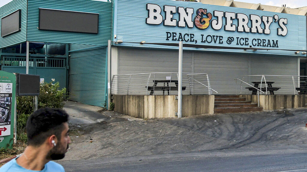 motorist drives past a closed "Ben & Jerry's" ice-cream shop in the Israeli city of Yavne, about 30 kilometres south of Tel Aviv, on July 23, 2021