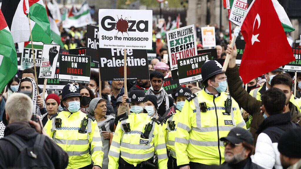 Protesters hold placards and banners in London, Saturday, May 22, 2021, as they take part in a rally supporting Palestinians