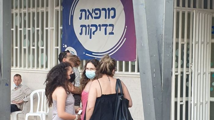 Israelis stand outside a COVID-19 testing site in the southern city of Be'er Sheva, August 2021 
