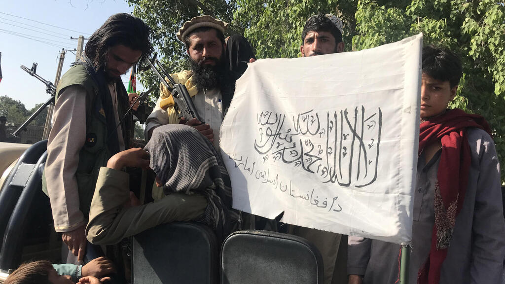 Taliban militants display their flag after taking control of Jalalabad, in Nangarhar province, Afghanistan, 15 August 2021