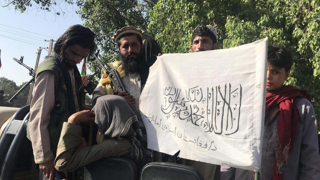 Taliban militants display their flag after taking control of Jalalabad, in Nangarhar province, Afghanistan, 15 August 2021
