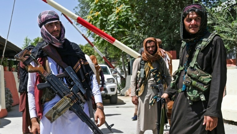 Taliban fighters stand guard on a road near Zanbaq Square in Kabul 