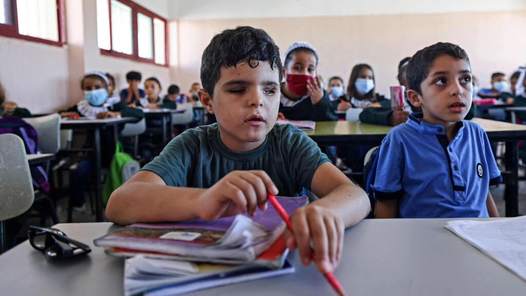 Palestinian pupil Mohammed Shaban (L) sits alongside classmates at school in beit Lahia, in the northern Gaza Strip