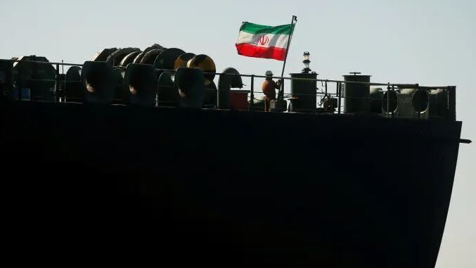 A crew member raises the Iranian flag on Iranian oil tanker Adrian Darya 1, previously named Grace 1, as it sits anchored after the Supreme Court of the British territory lifted its detention order, in the Strait of Gibraltar