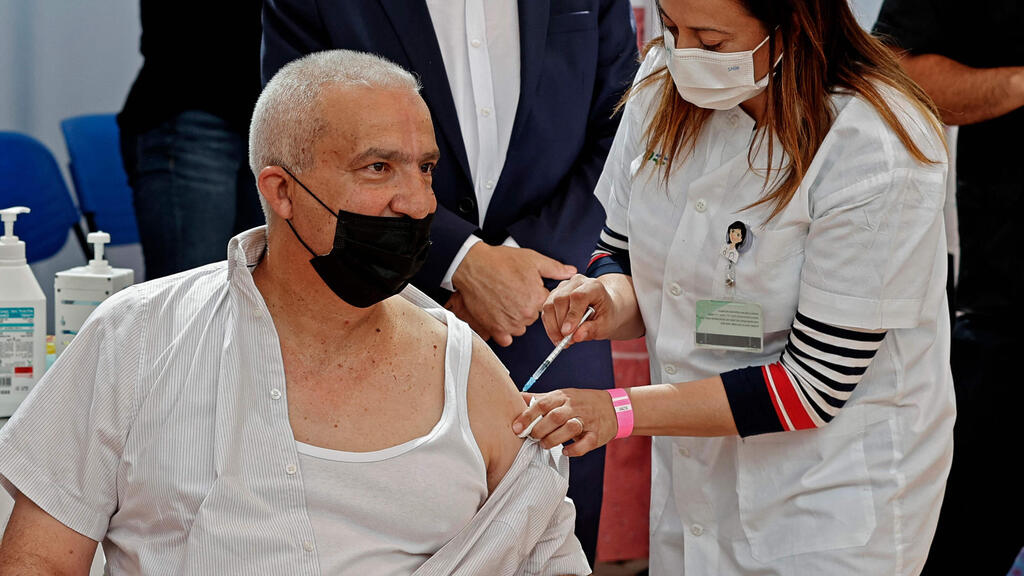 A man receives the third jab of the coronavirus vaccine in Tayibe last week (Photo: AFP) חיסון קורונה