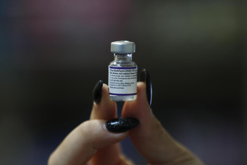 A healthworker holding a vial of Pfizer's coronavirus vaccine (Photo: EPA) מתחסנים בחיסון השלישי בירושלים