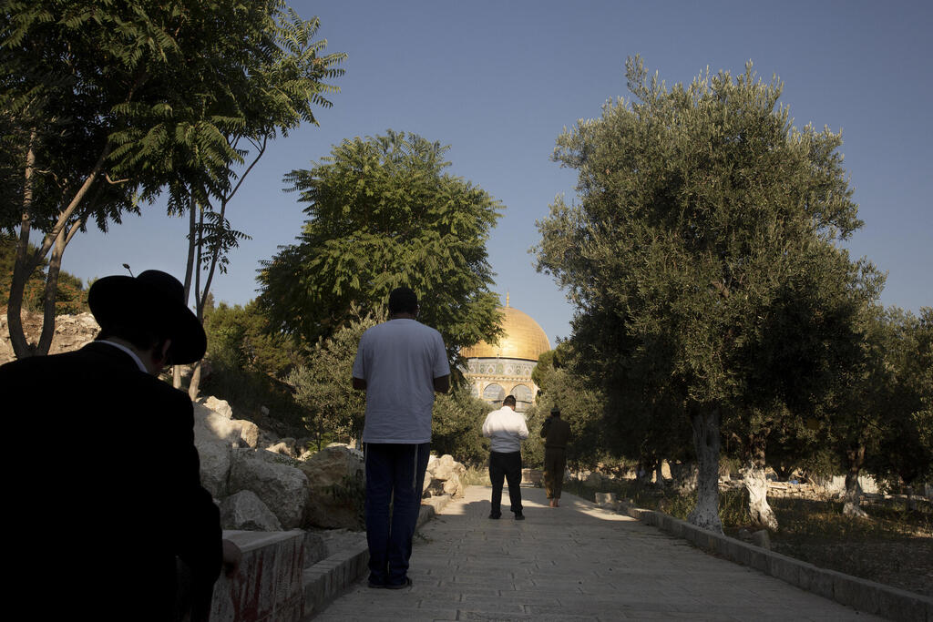 Religious Jews face the Temple Mount in the Old City of Jerusalem, Monday, Aug. 2, 2021