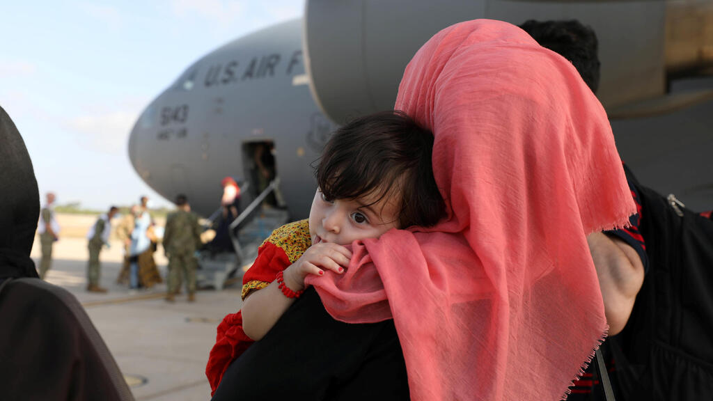 Afghan woman and her child arrive at Kuwait airport after being airlifted out of Afghanistan after Taliban takeover, August 28, 2021  
