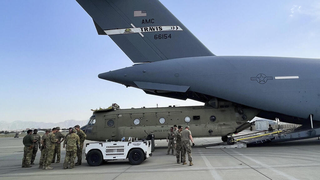 CH-47 Chinook from the 82nd Combat Aviation Brigade, 82nd Airborne Division is loaded onto a U.S. Air Force C-17 Globemaster III at Hamid Karzai International Airport in Kabul 