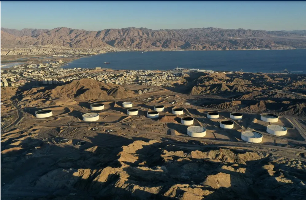 An aerial view of (foreground) oil storage containers of the Eilat Ashkelon Pipeline Company (EAPC) in the mountains near Israel's Red Sea port city of Eilat, and (background) the Jordanian coastline south of Aqaba on February 10, 2021