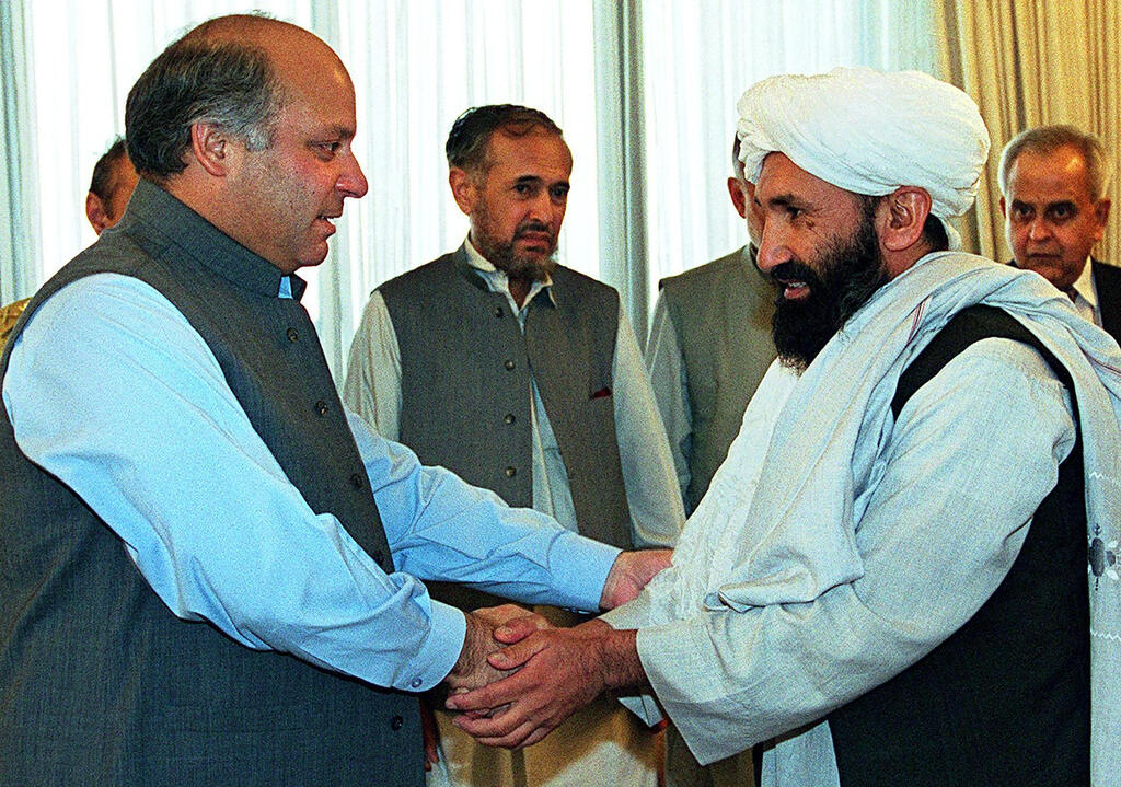בכיר טליבאן הטליבאן מולא מוחמד חסן אחונד (ימין) בתמונה ישנה מ-1999 לוחץ ידיים עם ראש ממשלת פקיסטן דאז