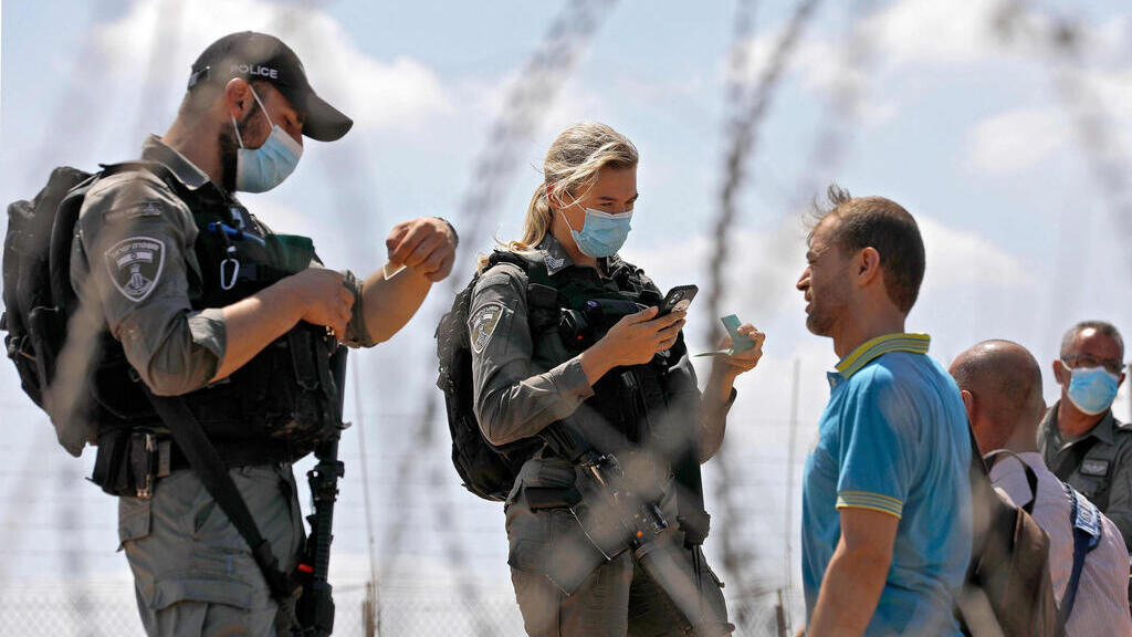 Police forces question Palestinian workers near the border crossing into the northern West Bank on Tuesday 