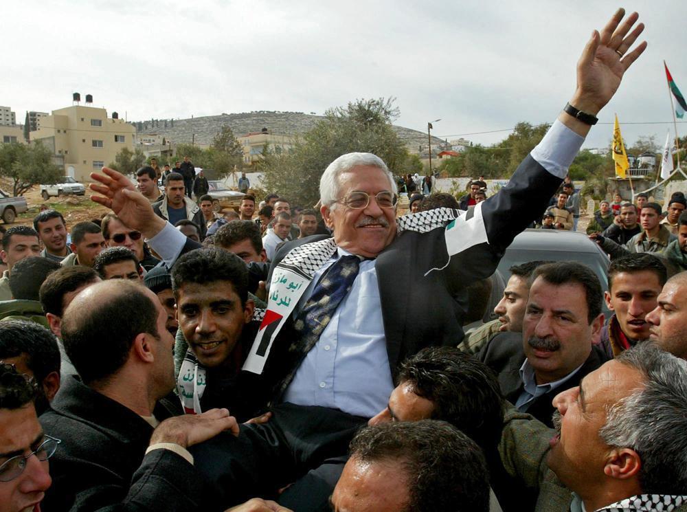 then Interim Palestinian leader Mahmoud Abbas, and front-runner in the upcoming presidential elections, is carried by the Al Aqsa Martyrs' Brigades leader in West Bank, Zakaria Zubeidi, center left, during a campaign visit to the Jenin refugee camp 