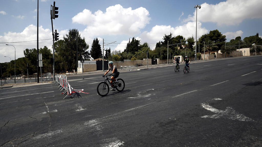 Israelis on bikes in an empty street during the Jewish Holiday of Yom Kippur in Jerusalem, 16 September 2021 
