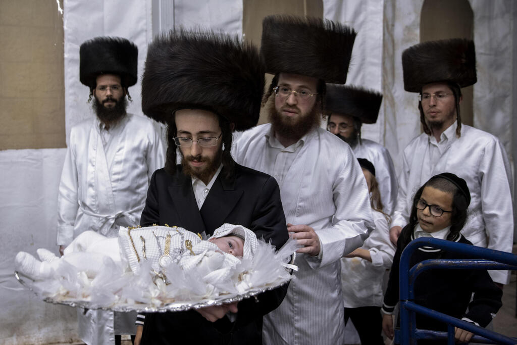 Tabersky carries his 30-day-old son Yossef, the great grandchild of the chief rabbi of the Lelov Hassidic dynasty, during a pidyon haben ceremony in Beit Shemesh, Israel, Thursday, Sept. 16, 2021