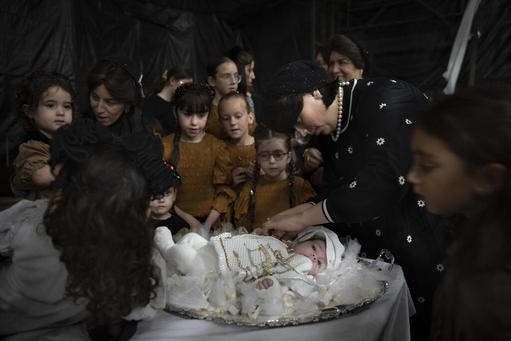 Ultra-Orthodox Jewish women adorn 30-day-old Yossef Tabersky during his pidyon haben ceremony in Beit Shemesh, Israel, Thursday, Sept. 16, 2021