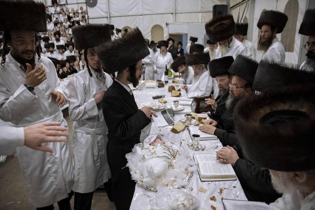 Tabersky, left, presents his firstborn son Yossef on a silver platter to Jewish priests from the Lelov Hassidic dynasty, during a pidyon haben ceremony in Beit Shemesh, Israel, Thursday, Sept. 16, 2021