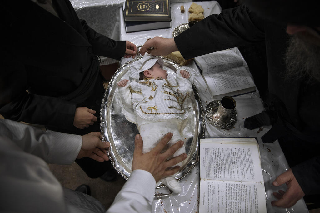 Yaakov Tabersky, left, presents his firstborn son Yossef on a silver platter to Jewish priests from the Lelov Hassidic dynasty, during a pidyon haben ceremony in Beit Shemesh, Israel, Thursday, Sept. 16, 2021