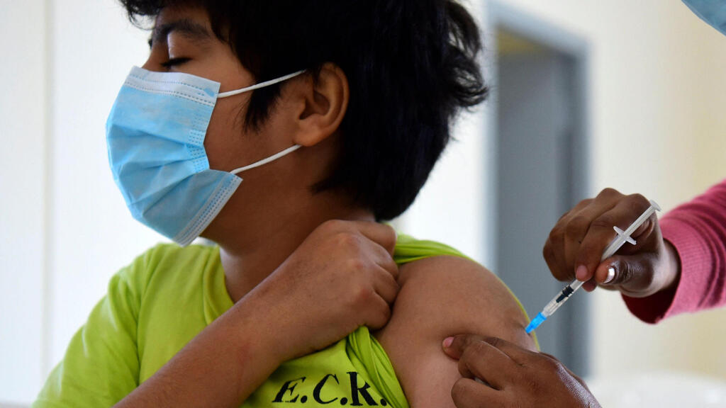 נער מקבל חיסון לקורונה בפרגוואי
