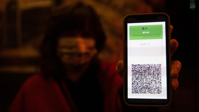 A woman shows the Green Pass on her phone 