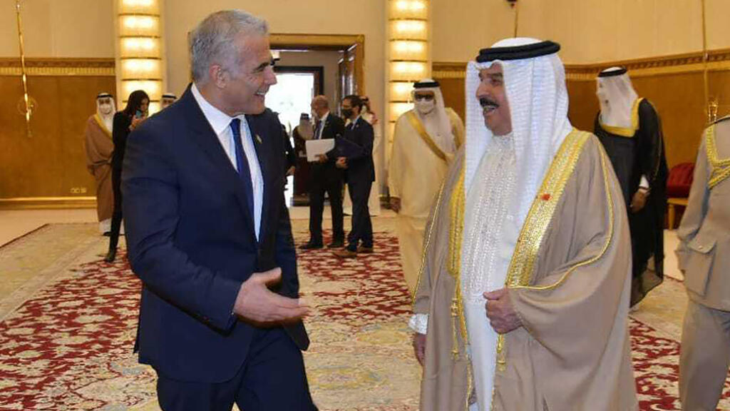 s Foreign Minister Yair Lapid, center left, walks with Bahraini King Hamid bin Issa al Khalifa,