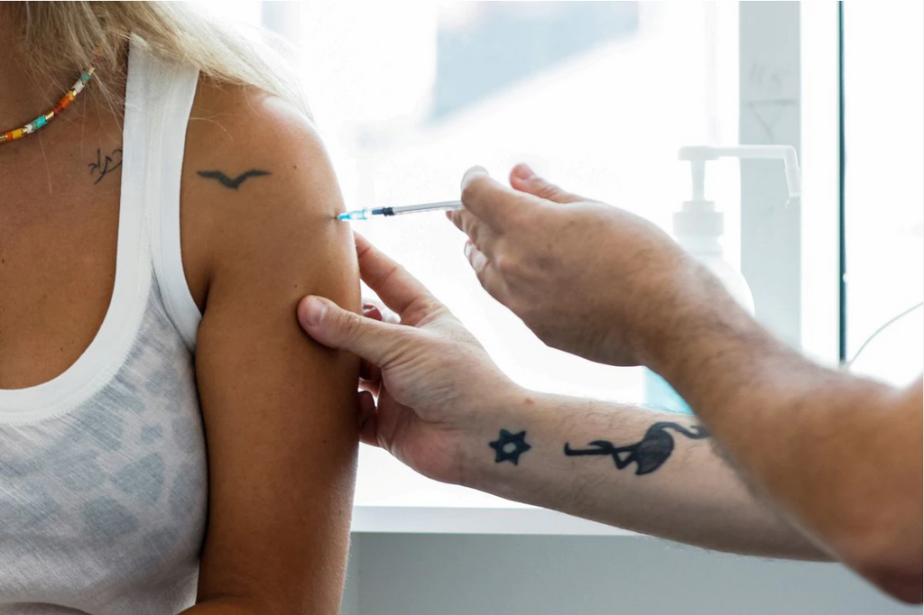 An Israeli woman receives her third shot of coronavirus vaccine in Tel Aviv, August 30, 2021
