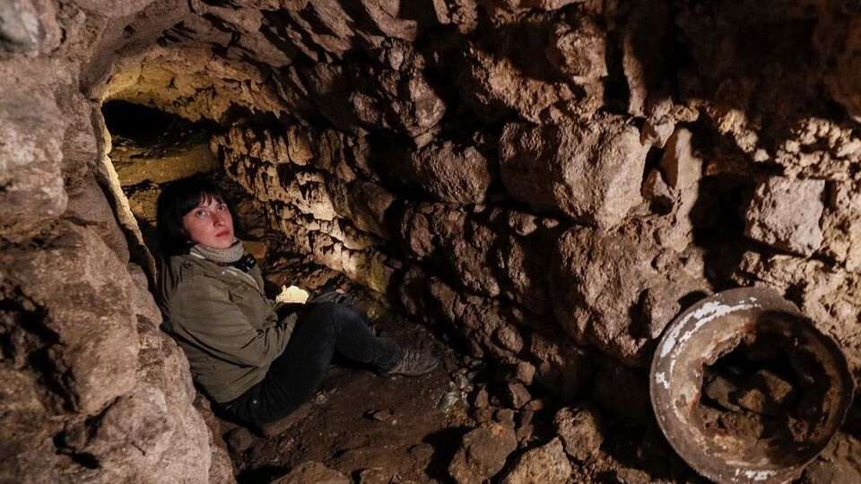 Historian Hanna Tychka explores a cave at the city sewage system where dozens of Jews were hiding from the Nazis during World War Two in Lviv, Ukraine