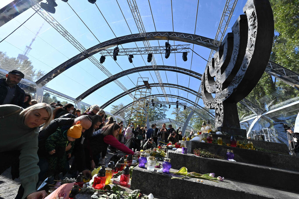 People lay flowers and set lamps to Minora memorial in Kiev