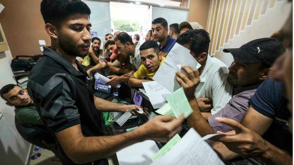 Palestinian men gather to apply for work permits in Israel, at Jabalia refugee camp in the northern Gaza Strip