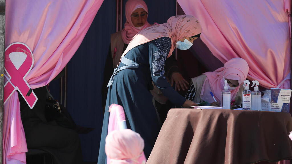 A Palestinian woman registers before a breast cancer check up inside a mobile clinic set up in a truck, during a campaign aimed to raise public awareness in Gaza 