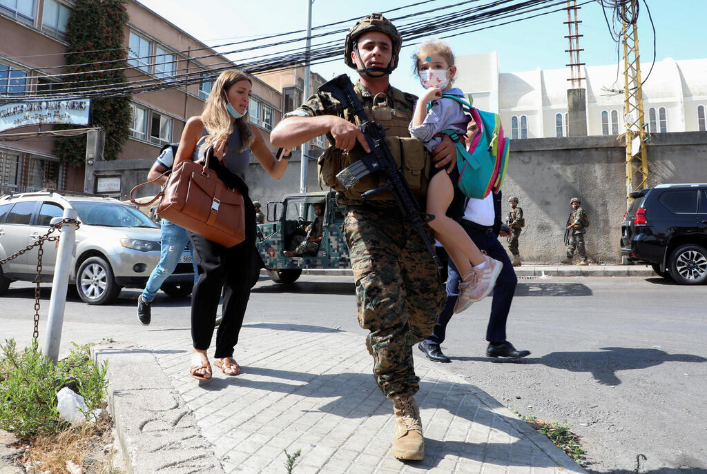 לבנון ביירות מהומות עימותים תומכי חיזבאללה אמל ו נוצרים חייל מפנה ילד