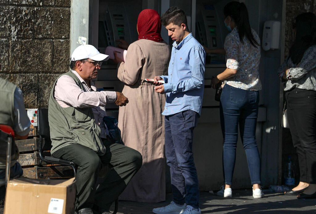 A Palestinian man exchances banknotes in the West Bank city of Ramallah on 