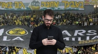 משה חוגג על רקע דגל לה פמיליה